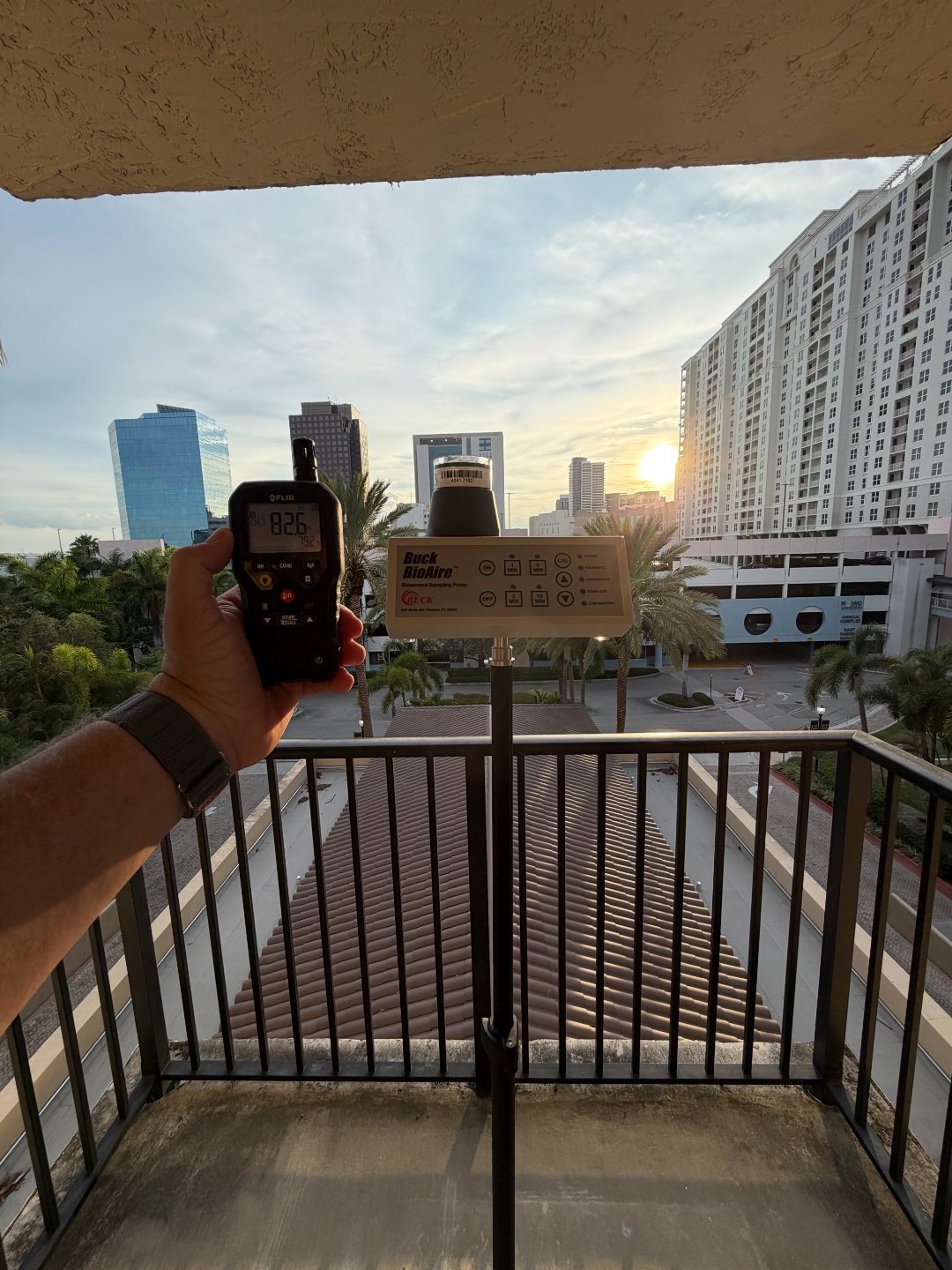 Air sampling pump collecting an outdoor baseline sample from the building balcony for comparison against indoor results.