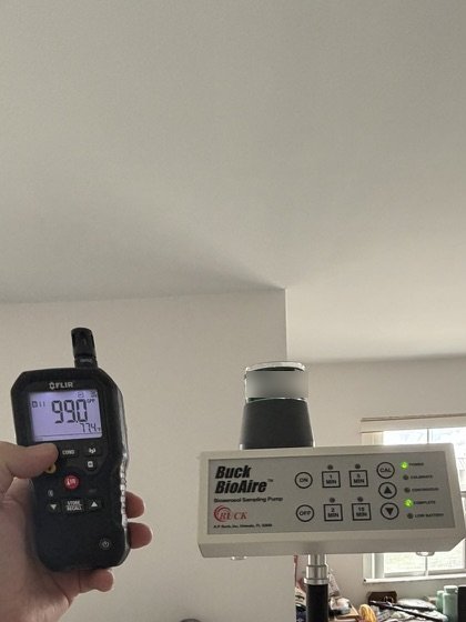 Buck BioAire air sampling pump set up in the TV and dining room for indoor air sampling, next to a FLIR handheld meter.