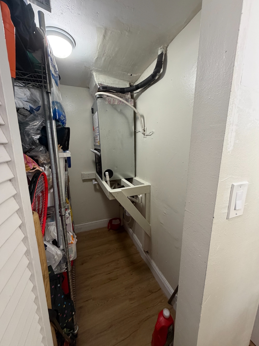 Overall view of a condominium AC closet evaluated after reported water intrusion from the unit above.